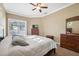Bright main bedroom featuring carpet floors, a ceiling fan, and ensuite bathroom access at 9127 Irondale Ln, Hudson, FL 34667