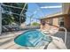 Enclosed pool with lounge chairs and view of the backyard at 9127 Irondale Ln, Hudson, FL 34667