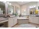 Bright bathroom features double sinks, granite countertops, walk-in shower, and large soaking tub at 922 Grand Cresta Ave, Brandon, FL 33511