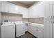 A well-organized laundry room featuring white cabinets, a counter top, and modern appliances for efficient laundry care at 922 Grand Cresta Ave, Brandon, FL 33511