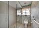 Bathroom featuring a walk-in shower with glass door, toilet, and decorated wallpaper at 927 Golf Island Dr, Apollo Beach, FL 33572