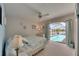 Inviting bedroom with a king bed, ceiling fan, and a view of the screened-in pool area at 927 Golf Island Dr, Apollo Beach, FL 33572