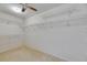 A walk-in closet with ceiling fan, neutral carpet, and multiple shelves for optimal storage at 927 Golf Island Dr, Apollo Beach, FL 33572