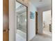 Bright hallway leading to a bathroom with a sliding glass shower door and a bedroom at 927 Golf Island Dr, Apollo Beach, FL 33572