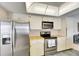 Bright kitchen showcases stainless steel appliances, white cabinetry, and durable tile flooring at 927 Golf Island Dr, Apollo Beach, FL 33572
