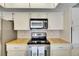 Bright kitchen features stainless steel appliances and white cabinetry at 927 Golf Island Dr, Apollo Beach, FL 33572