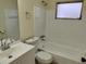 Bathroom featuring shower-tub combo, white fixtures, and a mirrored vanity at 10817 Fillmore Ave, Port Richey, FL 34668