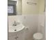 Bathroom featuring white vanity, toilet, and tiled walls with a framed mirror at 10817 Fillmore Ave, Port Richey, FL 34668