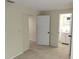Bedroom with tile flooring showing access to a bathroom and additional bedroom at 10817 Fillmore Ave, Port Richey, FL 34668