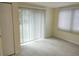Bedroom with tile flooring, light walls, and sliding glass doors with vertical blinds at 10817 Fillmore Ave, Port Richey, FL 34668
