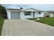 Charming single-story home featuring a brick driveway and attached one car garage at 10817 Fillmore Ave, Port Richey, FL 34668