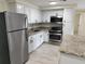 Modern kitchen boasts stainless steel appliances, granite countertops, and bright white cabinetry at 10817 Fillmore Ave, Port Richey, FL 34668