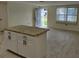 Bright living room with granite-topped kitchen island and tile floors at 10817 Fillmore Ave, Port Richey, FL 34668