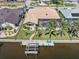 Aerial view of a waterfront home featuring a private boat dock, pool, screened-in lanai, and lush tropical landscaping at 1137 Treasure Cay Ct, Punta Gorda, FL 33950