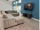 Comfortable living area featuring a large sectional sofa, modern entertainment center, and tile floors at 1137 Treasure Cay Ct, Punta Gorda, FL 33950