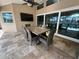Dining area on the covered patio with a television and scenic waterfront views at 1137 Treasure Cay Ct, Punta Gorda, FL 33950