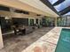 Covered patio featuring a dining table and cushioned seating area adjacent to the pool at 1137 Treasure Cay Ct, Punta Gorda, FL 33950