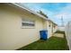 Rear exterior view of a well-maintained house with a lush backyard and a blue recycle bin at 1180 39Th N St, St Petersburg, FL 33713