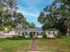Charming single story home with mature trees, neat landscaping, walkway, and neutral color scheme at 1180 39Th N St, St Petersburg, FL 33713
