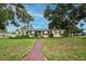 Charming single-story home with a well-manicured lawn, lush landscaping, and a welcoming walkway to the front door at 1180 39Th N St, St Petersburg, FL 33713
