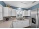 Charming kitchen with white cabinetry, stainless steel refrigerator, and tile backsplash at 1180 39Th N St, St Petersburg, FL 33713