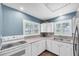 Bright kitchen features white cabinets, stainless steel appliances, and ample natural light from large windows at 1180 39Th N St, St Petersburg, FL 33713