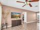 Cozy living room with tile flooring, a ceiling fan, modern TV and a view into the next room at 1180 39Th N St, St Petersburg, FL 33713