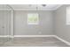 Empty bedroom with white trim, and tile flooring illuminated by plantation shuttered window at 1183 35Th Ne Ave, St Petersburg, FL 33704