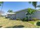 Exterior side view of home featuring manicured lawn and tropical palm trees at 1183 35Th Ne Ave, St Petersburg, FL 33704