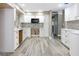 Stylish kitchen with white cabinets, herringbone backsplash, and light wood-look floors at 1183 35Th Ne Ave, St Petersburg, FL 33704