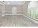 Inviting living room featuring arched windows with white plantation shutters, crown molding, and light tile flooring at 1183 35Th Ne Ave, St Petersburg, FL 33704