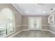 Bright living room filled with natural light, accentuated by an arched window and French doors with white plantation shutters at 1183 35Th Ne Ave, St Petersburg, FL 33704