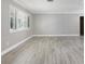 Bright living room featuring light wood-look floors, plantation shutters, and neutral paint at 1183 35Th Ne Ave, St Petersburg, FL 33704