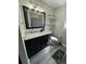 Modern bathroom with a black vanity, white marble countertop and decorative shelves at 1211 E Curtis St, Tampa, FL 33603