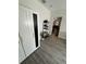 Hallway featuring gray vinyl flooring, storage and an open doorway to living area at 1211 E Curtis St, Tampa, FL 33603