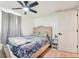 Bedroom features a ceiling fan, light wood floors, upholstered headboard and window view at 12701 Cornell Ct, Hudson, FL 34667