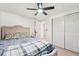 Bedroom features a ceiling fan, light wood floors, closet, and upholstered headboard at 12701 Cornell Ct, Hudson, FL 34667