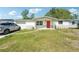 Charming single-story home with a well-manicured front lawn and a vibrant red front door at 12701 Cornell Ct, Hudson, FL 34667