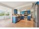Corner kitchen features stainless steel appliances, light countertops and bright blue cabinets at 12701 Cornell Ct, Hudson, FL 34667