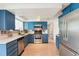 Modern kitchen with custom blue cabinets, stainless steel appliances, and bright white countertops at 12701 Cornell Ct, Hudson, FL 34667