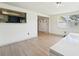 Bright living room features light wood floors, white walls, and views to kitchen and backyard at 12701 Cornell Ct, Hudson, FL 34667