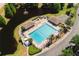 View of community swimming pool, deck chairs, and covered seating near lush landscaping and a pond at 12815 Tallowood Dr, Riverview, FL 33579