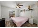 Cozy bedroom features a ceiling fan, decorative shelf, and a window view of the pool at 12815 Tallowood Dr, Riverview, FL 33579