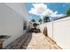 Long brick driveway with a boat, surrounded by a white fence and palm trees at 12815 Tallowood Dr, Riverview, FL 33579