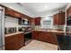 Well-equipped kitchen with stainless steel appliances, dark wood cabinets, and a tile backsplash at 12815 Tallowood Dr, Riverview, FL 33579