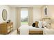 A bright bedroom featuring a stylish bed, a dresser, and plenty of natural light at 13186 Goldstone Ct, Wimauma, FL 33598
