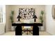 Contemporary office featuring sleek black desk, comfortable chair, and artistic wall décor at 13186 Goldstone Ct, Wimauma, FL 33598