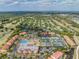 Wide aerial view of a community with tennis courts, a pool, lush green landscaping, and multiple buildings at 13610 S Village Dr # 4212, Tampa, FL 33618