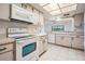 The open kitchen features white appliances, a cooktop, and a breakfast bar with natural light at 13610 S Village Dr # 4212, Tampa, FL 33618