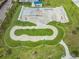 Aerial view of a modern skatepark with various ramps, rails, and a pump track, surrounded by lush greenery at 13610 S Village Dr # 4212, Tampa, FL 33618
